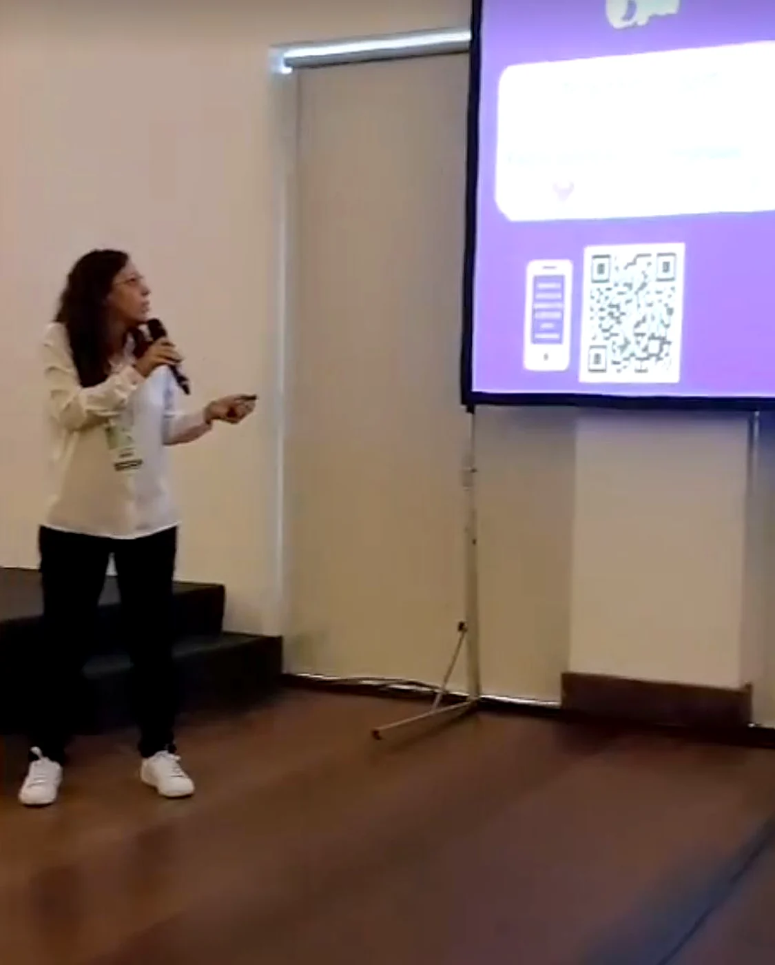 Tali Vasquez em palestra, com QR code no telão